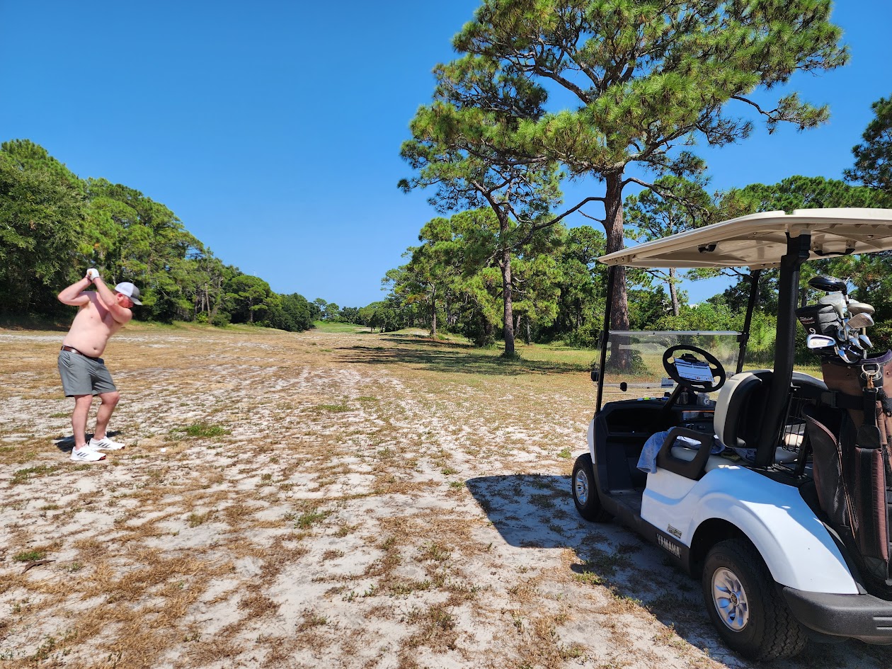 An HFFL owner taking a golf swing beside a cart