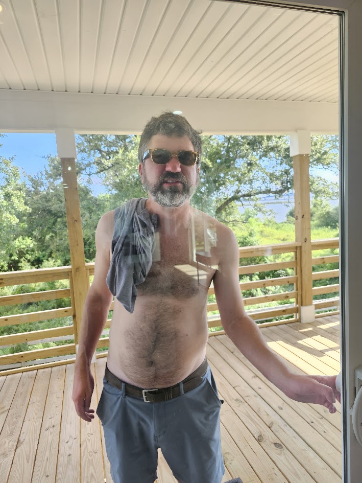 An HFFL owner standing at a porch door wearing sunglasses